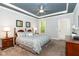 Bedroom with large bed, matching nightstands, and a ceiling fan with blue tray ceiling at 1101 Sky Wave Trl, Raleigh, NC 27603