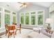 Bright sunroom featuring vaulted ceiling, large windows, hardwood floors, and a cozy seating area at 1101 Sky Wave Trl, Raleigh, NC 27603