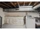 Basement laundry room features wooden cabinets and a white washing machine at 1105 Englewood Ave, Durham, NC 27701