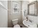 Charming powder room with a classic sink, modern fixtures, and bright natural light from window at 1105 Englewood Ave, Durham, NC 27701