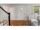 Bright foyer features gleaming hardwood floors, an arched doorway, and elegant chairs near staircase at 1105 Englewood Ave, Durham, NC 27701