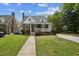 Charming brick home boasts a cozy front porch and beautifully landscaped front yard under a bright, cloudy sky at 1105 Englewood Ave, Durham, NC 27701