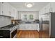 Charming kitchen featuring stainless steel appliances, white cabinets, and hardwood floors at 1105 Englewood Ave, Durham, NC 27701