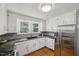 Well-lit kitchen features modern appliances, white cabinets, dark counters, and a view outdoors at 1105 Englewood Ave, Durham, NC 27701