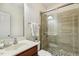 This bathroom features a glass shower with stone flooring, a modern vanity, and neutral wall colors at 1127 Woodlands Creek Way, Apex, NC 27502