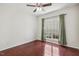 Bright, vacant bedroom with hardwood floors and a window with view of the green outdoor at 1127 Woodlands Creek Way, Apex, NC 27502