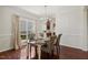 Dining area with hardwood floors, window, wainscoting, chandelier and a view of the kitchen at 1127 Woodlands Creek Way, Apex, NC 27502