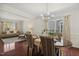 Dining room featuring hardwood floors, wainscoting, elegant lighting fixture, and seating for six at 1127 Woodlands Creek Way, Apex, NC 27502