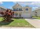 Charming two-story home with a well-manicured lawn, attached garage, and inviting front porch at 1127 Woodlands Creek Way, Apex, NC 27502