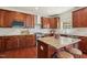 Kitchen with hardwood floors, an island, granite countertop, stainless steel appliances, and wood cabinets at 1127 Woodlands Creek Way, Apex, NC 27502