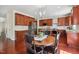 Kitchen with wooden cabinetry, granite countertops, stainless steel appliances, and adjacent wooden dining table at 1127 Woodlands Creek Way, Apex, NC 27502