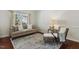 Cozy living room with neutral decor, hardwood floors, and a large window offering natural light at 1127 Woodlands Creek Way, Apex, NC 27502