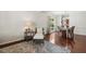 Comfortable living room with hardwood floors, bright light, and stylish rug with wicker chair at 1127 Woodlands Creek Way, Apex, NC 27502