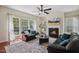 Comfortable living room with a fireplace, large windows, and neutral tones with a ceiling fan at 1127 Woodlands Creek Way, Apex, NC 27502