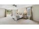 Spacious main bedroom featuring tray ceilings, soft carpet, and bright windows dressed in stylish draperies at 1127 Woodlands Creek Way, Apex, NC 27502