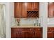 Wet bar with granite countertop, white backsplash, wine rack, and wood cabinets at 1127 Woodlands Creek Way, Apex, NC 27502