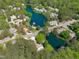 Aerial view of a neighborhood on a lake, featuring green space and mature trees at 113 Weatherhill Pt, Carrboro, NC 27510