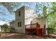 Rear exterior view of home with wood siding, a deck, and red painted stairs at 113 Weatherhill Pt, Carrboro, NC 27510