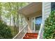 Inviting front entry features a covered porch with white railings and a red painted staircase at 113 Weatherhill Pt, Carrboro, NC 27510