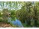 A serene pond reflects the surrounding trees, showcasing the natural beauty of the property at 113 Weatherhill Pt, Carrboro, NC 27510