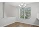 Bright dining area featuring wood floors, a modern chandelier, and a large window with natural light at 1217 Neighborly Way, Morrisville, NC 27560