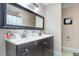 Well-lit bathroom featuring a double vanity, large mirror, and tiled flooring creating a modern and clean aesthetic at 13 Thorne Ridge Dr, Durham, NC 27713