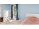 Light blue bedroom features a large window, blue curtains, white furniture, and a plush pink blanket at 13 Thorne Ridge Dr, Durham, NC 27713