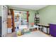 Versatile bedroom or craft room with bright green walls, featuring large windows, craft tables, and storage spaces at 13 Thorne Ridge Dr, Durham, NC 27713