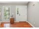 A bright entryway with hardwood floors, a wooden accent cabinet, and a white front door at 13 Thorne Ridge Dr, Durham, NC 27713
