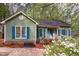 Charming single-story home featuring a well-maintained yard, complemented by green siding and teal-colored window shutters at 13 Thorne Ridge Dr, Durham, NC 27713