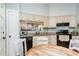 Cozy eat-in kitchen with white cabinets, wood floors, and a sunlit breakfast area leading to the back at 13 Thorne Ridge Dr, Durham, NC 27713