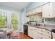 Bright kitchen with white cabinets, granite countertops, stainless steel appliances, and an adjacent breakfast nook at 13 Thorne Ridge Dr, Durham, NC 27713