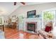 Bright living room with a brick fireplace, hardwood floors, and large windows with natural light at 13 Thorne Ridge Dr, Durham, NC 27713