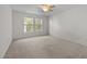 Bright, carpeted bedroom with two windows providing ample natural light and a ceiling fan at 1322 Pebble Creek Xing, Durham, NC 27713