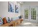 Bench seating area with pillows and wall art leading to a door with natural light at 1322 Pebble Creek Xing, Durham, NC 27713