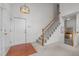 Welcoming foyer with staircase, hardwood accents, and ample natural light showcases a charming entry at 1322 Pebble Creek Xing, Durham, NC 27713