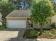 Inviting home with a well-maintained lawn, white garage door, and a beautiful shade tree at 1322 Pebble Creek Xing, Durham, NC 27713