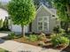 Charming home featuring mature landscaping, neutral siding, and a welcoming entrance with large windows at 1322 Pebble Creek Xing, Durham, NC 27713