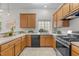 Bright kitchen features wooden cabinets, stainless steel appliances, and a window over the sink at 1322 Pebble Creek Xing, Durham, NC 27713