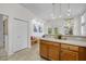 Open kitchen with wooden cabinets, adjacent bench seating, and access to the outdoors at 1322 Pebble Creek Xing, Durham, NC 27713