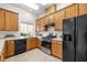 Galley kitchen features wooden cabinets, modern appliances, and a bright window at 1322 Pebble Creek Xing, Durham, NC 27713
