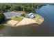 Stunning aerial view of waterfront property with sandy beach, volleyball court, and recreation center at 140 Clear Water Rd, Louisburg, NC 27549