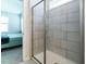 Modern bathroom features tiled shower with glass door, view to bedroom with carpet, bed and nightstand at 140 Clear Water Rd, Louisburg, NC 27549