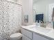 Bathroom features white vanity with sink, toilet, shower curtain with colorful dots, and large mirror at 140 Clear Water Rd, Louisburg, NC 27549