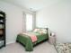 Bedroom with a twin bed, carpeted floors, bookcase and a window with patterned curtains at 140 Clear Water Rd, Louisburg, NC 27549