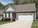 Charming single-Gathering home featuring a two-car garage and stone accents on a well-manicured lawn at 140 Clear Water Rd, Louisburg, NC 27549