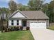 Charming single-Gathering home featuring a two-car garage and stone accents on a well-manicured lawn at 140 Clear Water Rd, Louisburg, NC 27549