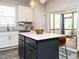 Kitchen island features white countertop, dark gray cabinets, and convenient seating near sliding glass door at 140 Clear Water Rd, Louisburg, NC 27549