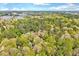 Lush aerial perspective of a home embraced by vibrant trees, with a neighborhood visible in the distance at 1433 Andersonwood Dr, Fuquay Varina, NC 27526