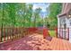 View of the spacious, stained-wood back deck overlooking the beautiful, wooded backyard at 1433 Andersonwood Dr, Fuquay Varina, NC 27526